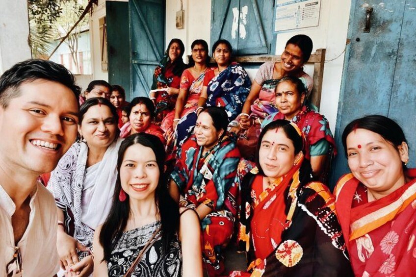 A group of people in traditional attire, standing in front of a building with a blue door. 5