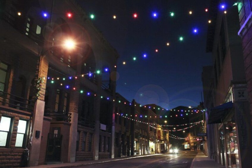 A street at night with string lights and buildings. 1