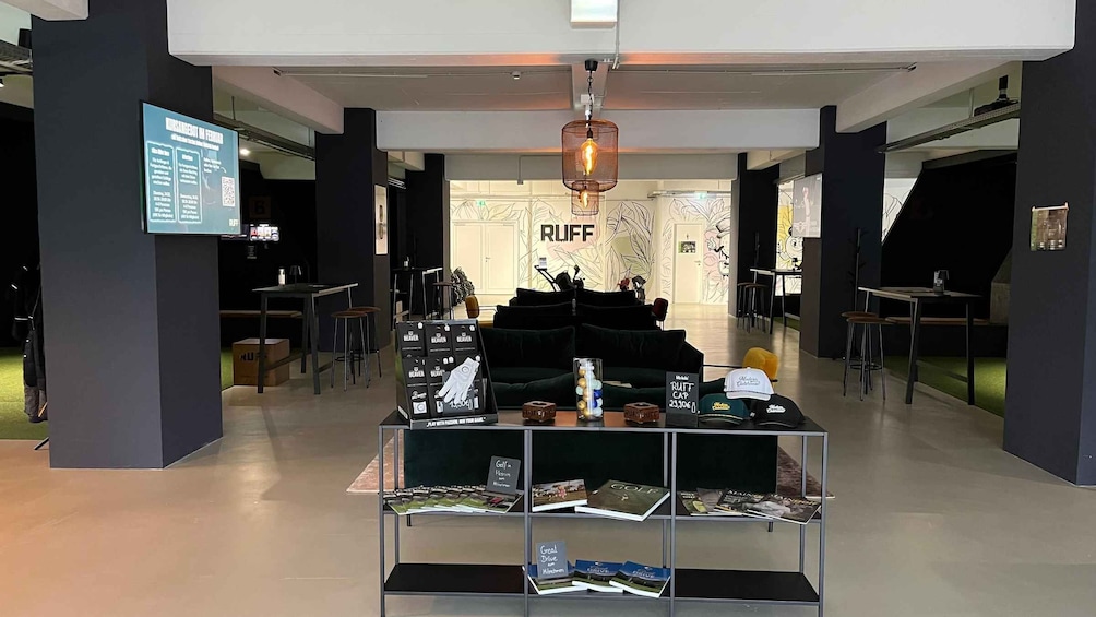 A modern interior with a central display of golf-related items, a hanging light fixture, and a wall with the word 'RUFF' prominently displayed. 4