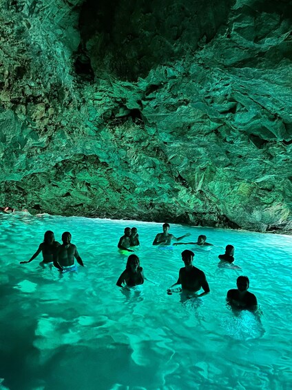 Un gruppo di persone in una piscina naturale circondata da pareti rocciose. 3