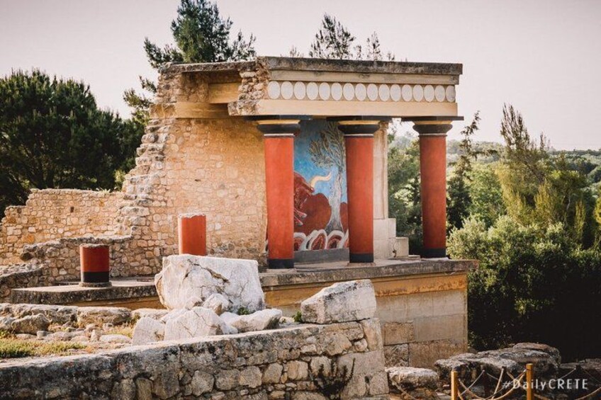 An ancient Greek temple with red columns and a mural. 1