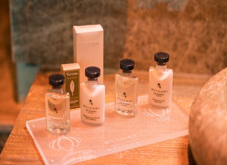 A wooden surface with three perfume bottles and a box. 3