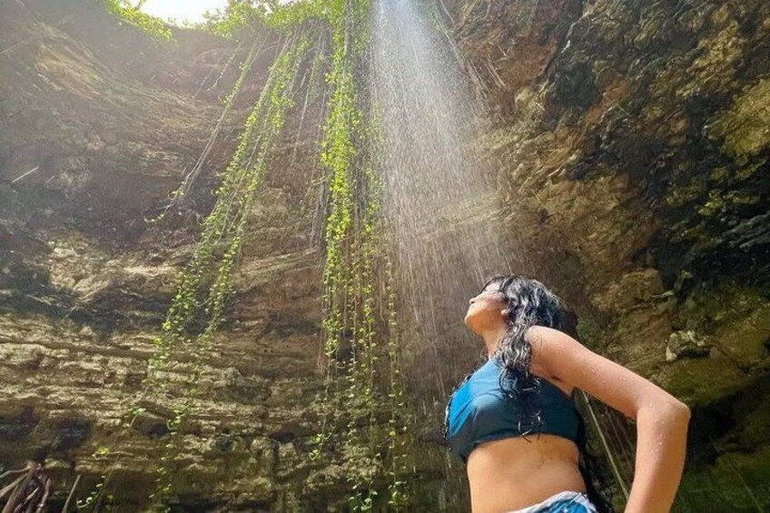 Una persona parada en una cueva con gotas de agua cayendo del techo. 3