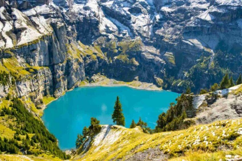 A mountain lake surrounded by rocky cliffs and greenery. 3