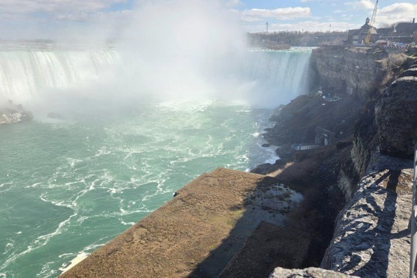 A waterfall, rocky shoreline, and a distant construction crane. 4