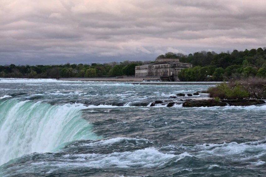 A waterfall, turbulent water, and a building in the background. 2