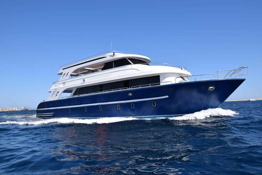 Un'imponente yacht blu e bianco che naviga sull'oceano. 1