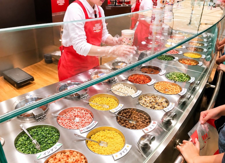 A buffet with various food items, a person serving, and a customer. 5