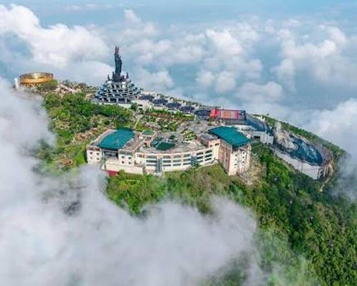 A mountainous landscape with a temple-like structure, a large building with a green roof, and a circular building. 5