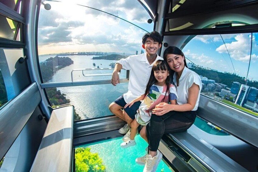 A cable car with passengers overlooking a river and cityscape. 1