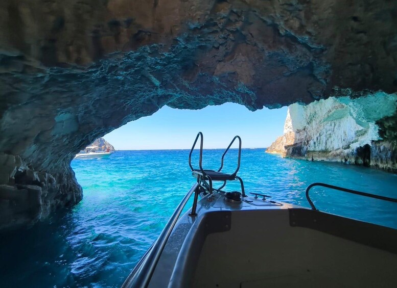 A boat's interior with a view of the sea through a rocky cave opening. 2