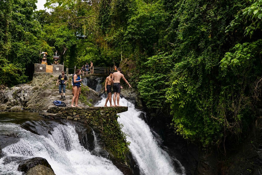 Ein Wasserfall mit Menschen, die auf einer Steinterrasse stehen. 4