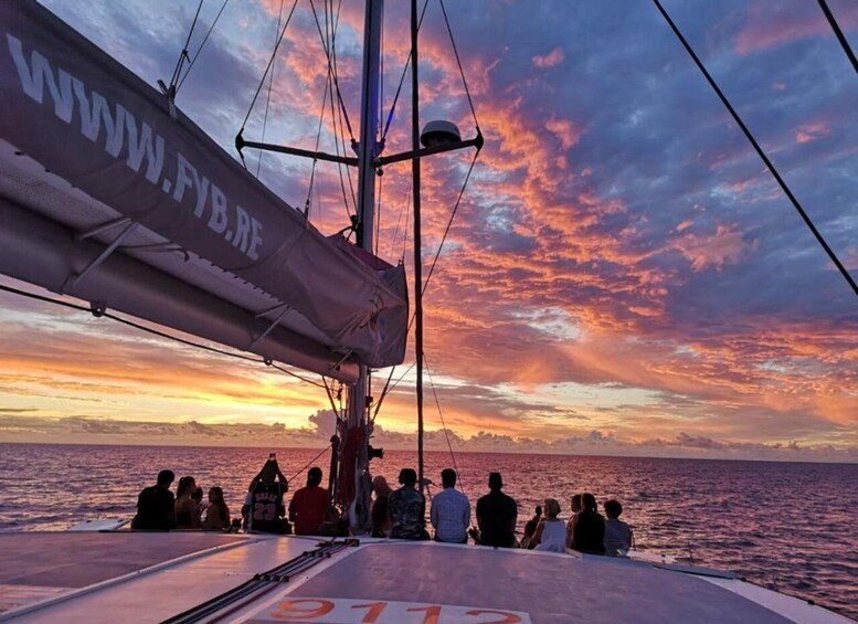 Una barca a vela con persone a bordo al tramonto. 5