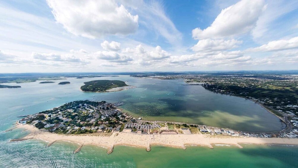 An aerial view of a coastal area with a large bay, several small islands, and a densely populated peninsula with buildings and roads. 3