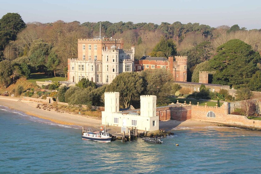 A castle with a tower, a beach, and a boat in the water. 2