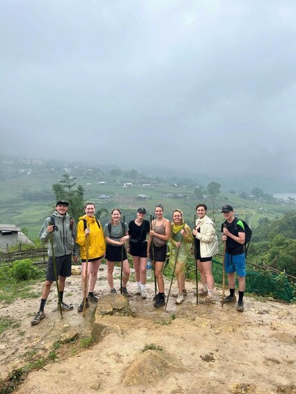 Un groupe de randonneurs sur un sentier de montagne, avec en arrière-plan une vue sur des champs en terrasses. 2