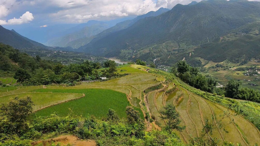 Des rizières en terrasses, une chaîne de montagnes et un petit village. 5