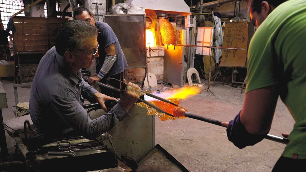 Una persona trabajando con vidrio fundido en un taller. 1