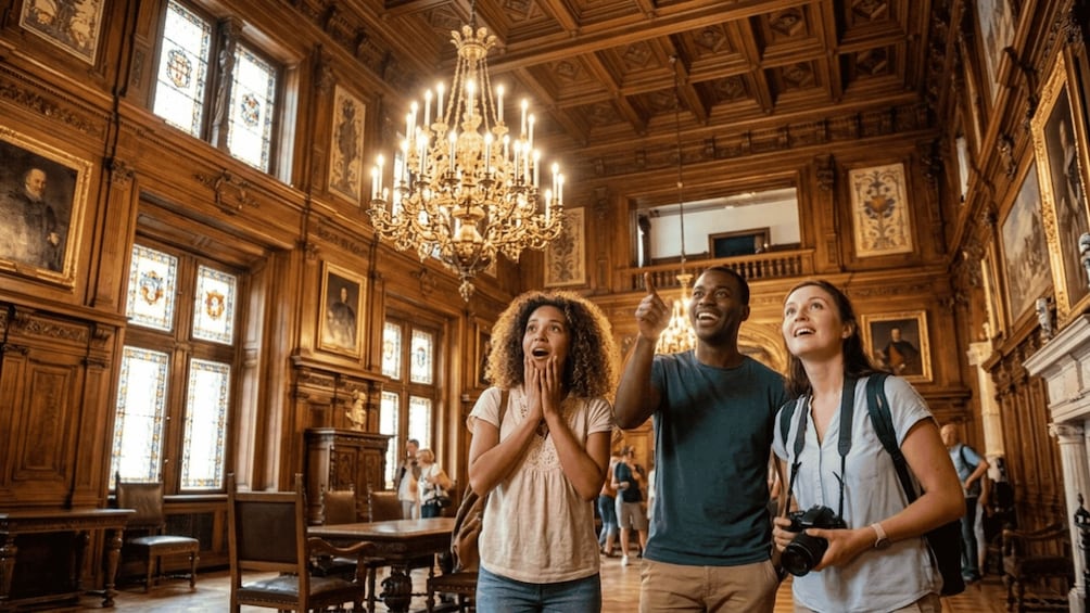 A grand hall with ornate wooden ceilings, a large chandelier, and stained glass windows. 2