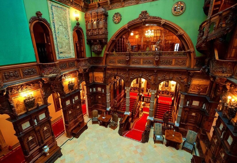An ornate room with intricate woodwork, red carpets, and a chandelier. 4