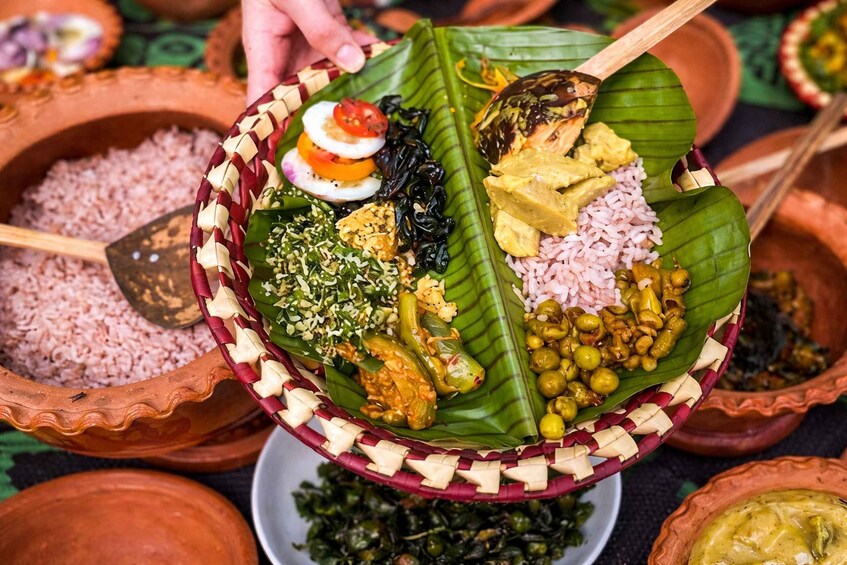 Eine traditionelle indische Mahlzeit, serviert auf Bananenblättern, mit verschiedenen Gerichten wie Reis, Gemüse und einem gekochten Ei. 2