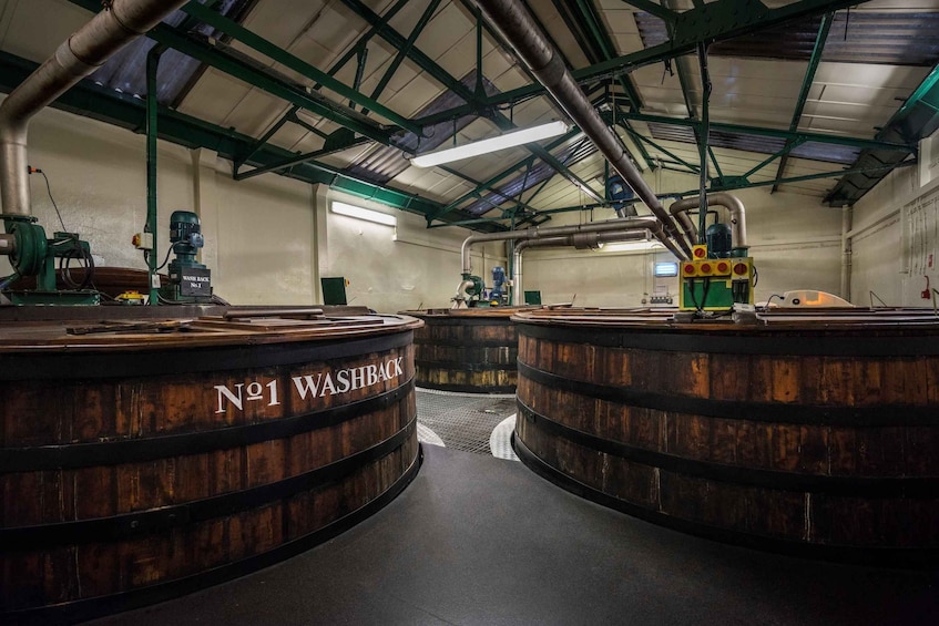 A large industrial space with two large wooden barrels labeled 'No 1 Washback' and various machinery and pipes. 4