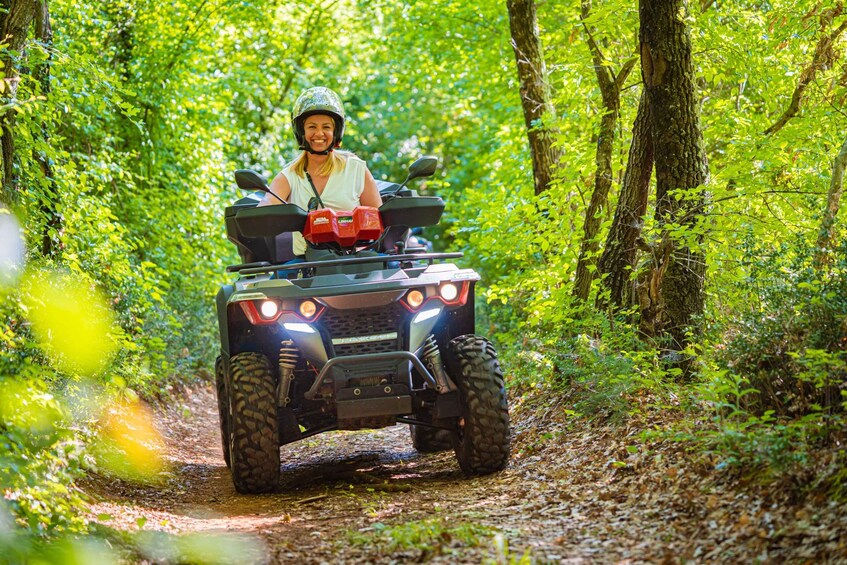 A person riding an ATV on a forest trail. 1