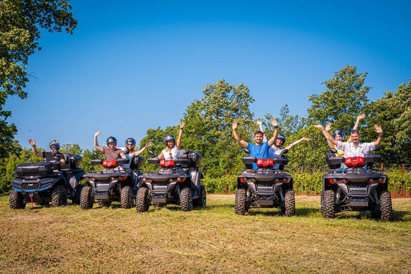 A group of people on ATVs in a grassy field with trees in the background. 4
