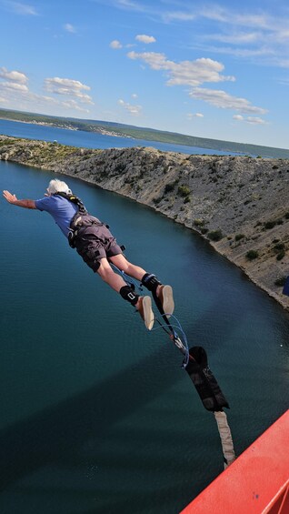 A person bungee jumping from a bridge over a body of water. 4