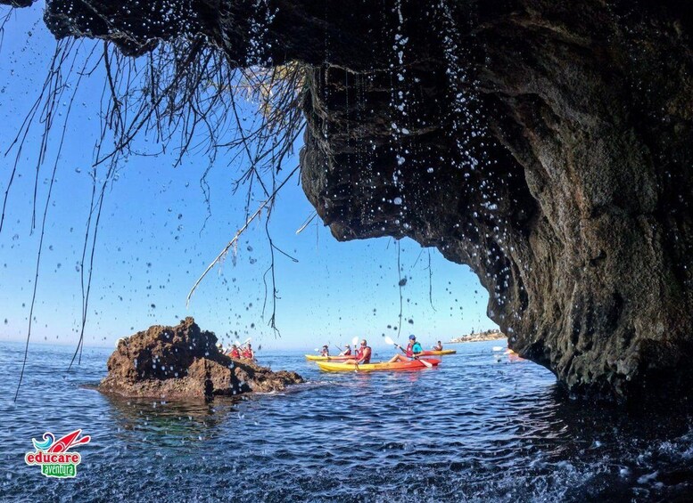 Kayakistas en una cala con la entrada de una cueva rocosa. 5