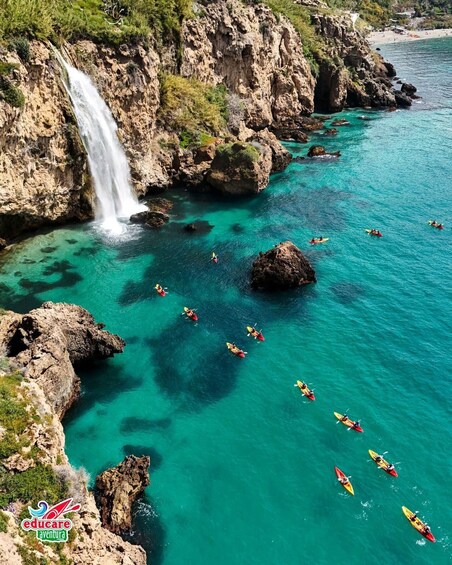 Una cascada, agua turquesa cristalina y personas haciendo kayak. 1