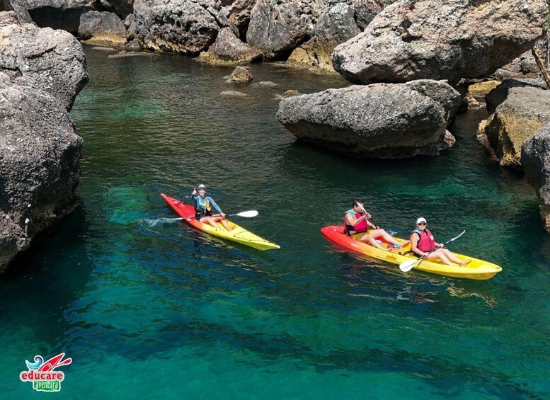 Dos personas hacen kayak en un río limpio rodeado de rocas grandes. 4