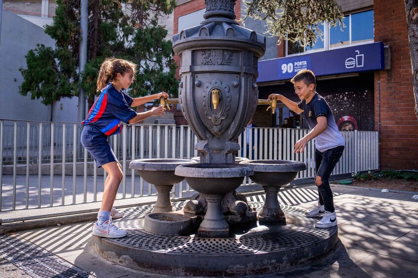 Two people playing a game at a public fountain. 3