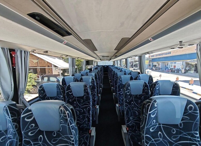 Ein Autobusinnenraum mit Sitzreihen, Fenstern und Blick nach draußen. 3