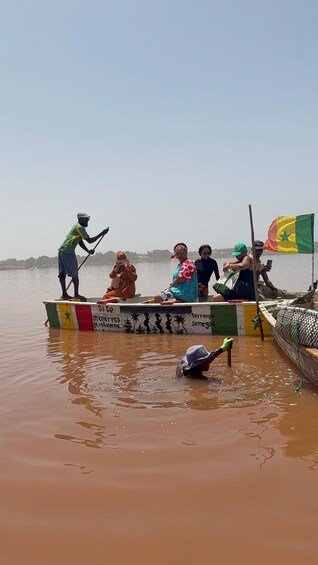 A group of people on a boat in a river with a flag and a sign that says 'SITU'. 1