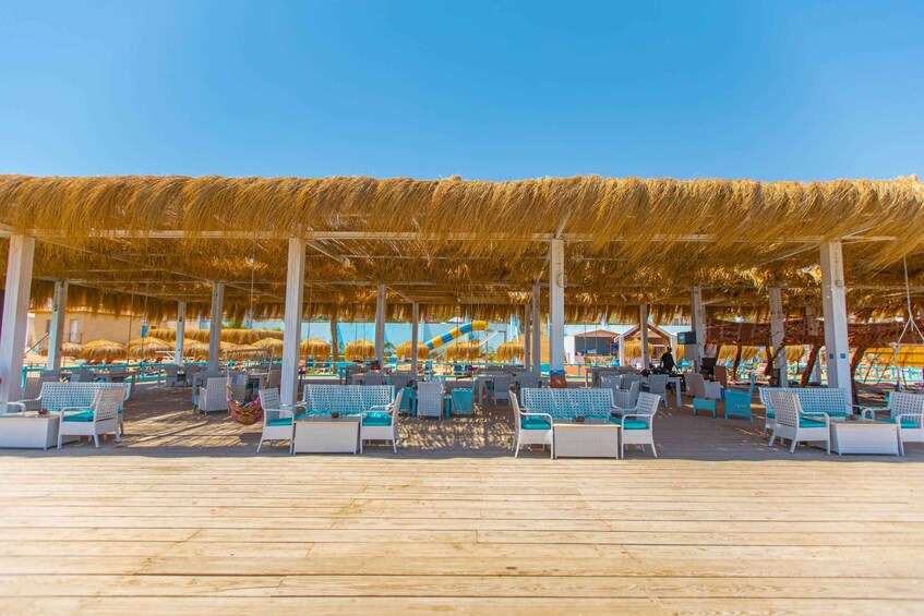 A beachside café with thatched umbrellas and white wicker furniture. 3