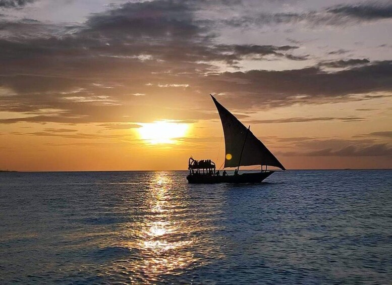 A boat with a sail on the water during sunset. 4