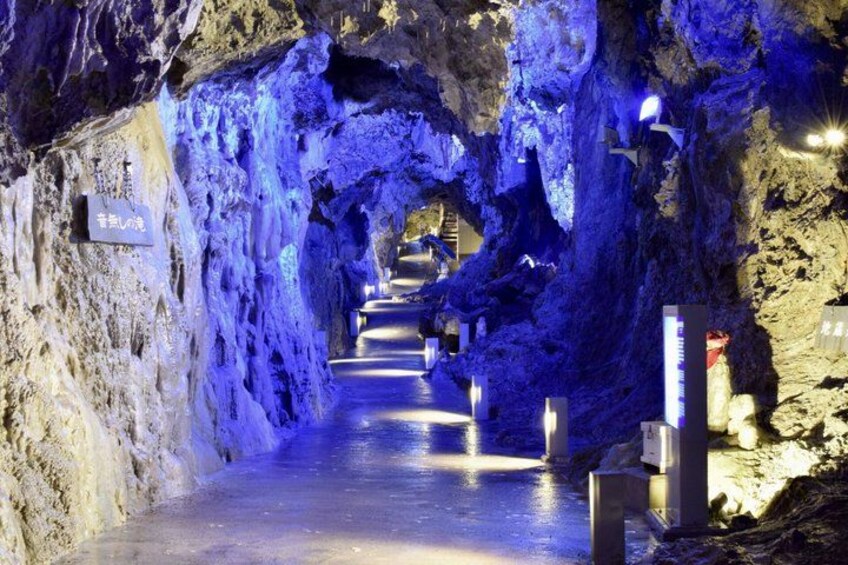 A cave pathway with blue lighting and stone walls. 5