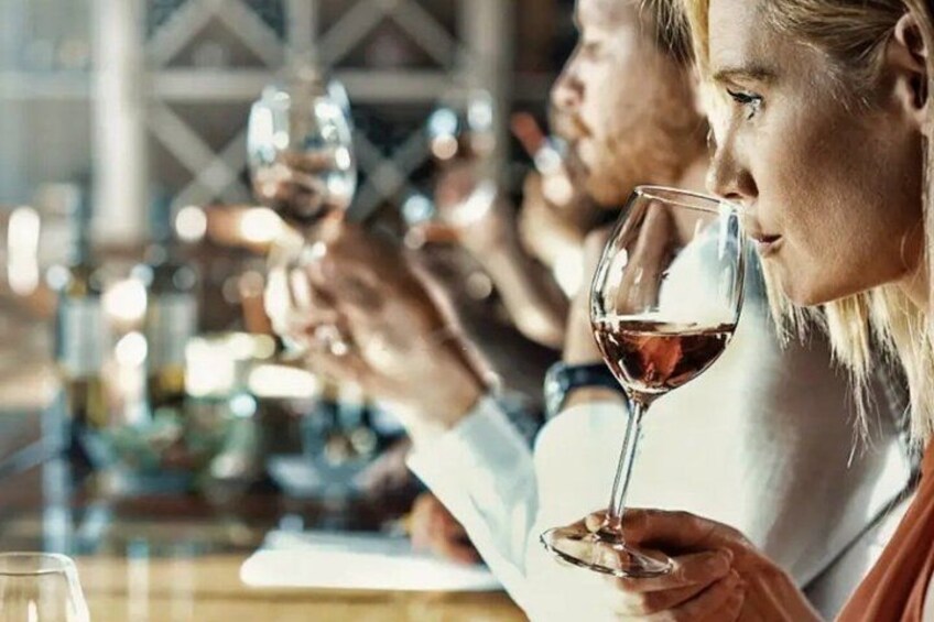 A person holding a wine glass, likely in a social setting with other people. 2