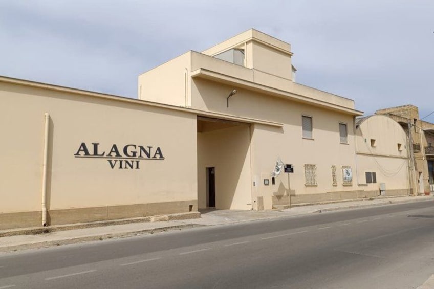 A building with the sign 'ALAGNA VINI' on its facade. 1