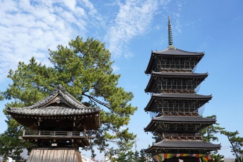 Una pagoda japonesa tradicional con varios niveles, rodeada de exuberantes árboles verdes. 1