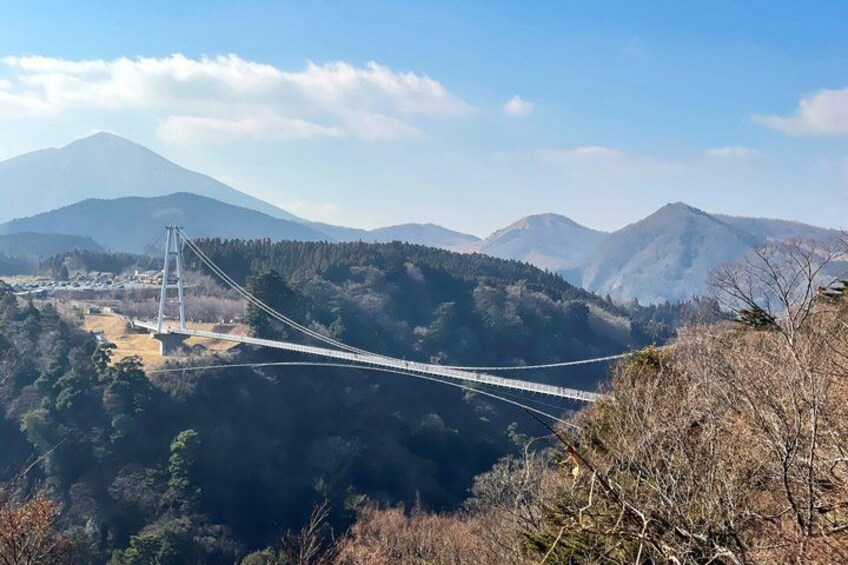 A suspension bridge over a valley with mountains in the background. 4