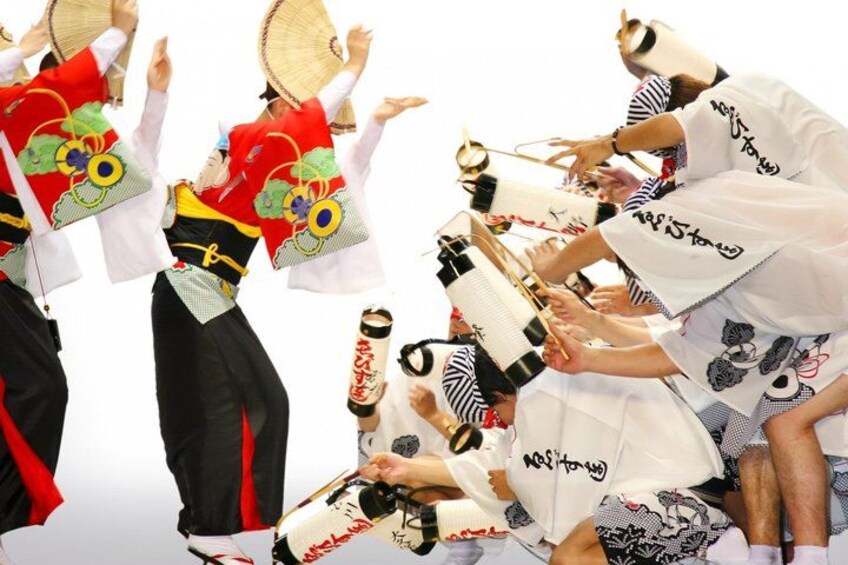 A group of people in traditional Japanese attire performing a dance with fans and drums. 3