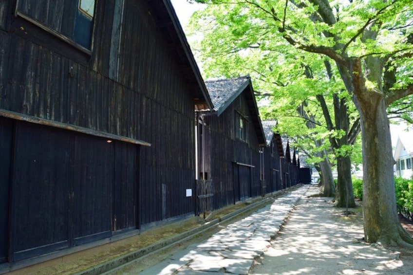 A row of dark wooden buildings with a narrow pathway between them. 1