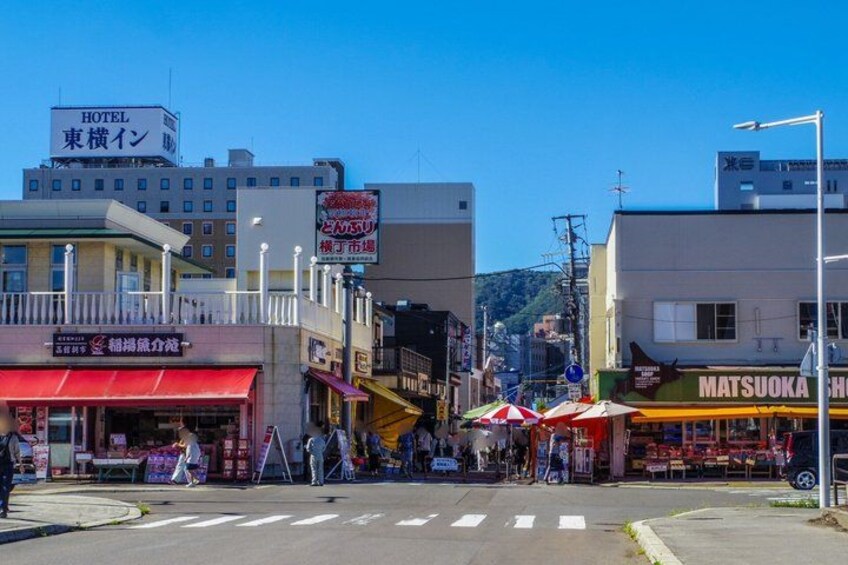 A street with buildings, a hotel sign, and a Matsukawa shop. 3