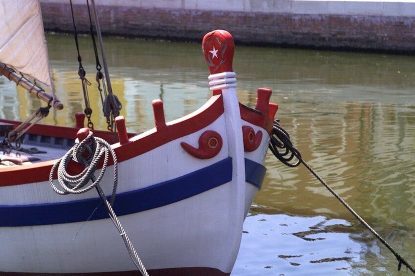 A boat with a red and white color scheme, a star on the bow, and a rope tied to the side. 5