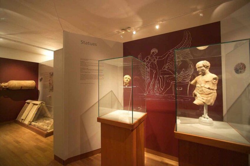 A museum exhibit with glass display cases containing sculptures. 2