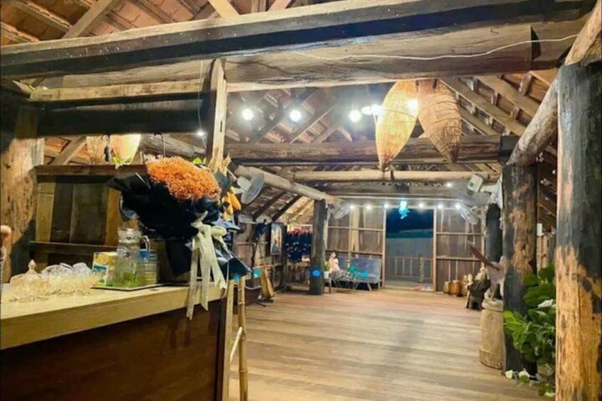 Una estructura interior de madera con techo alto, vigas de madera y faroles colgantes. 4