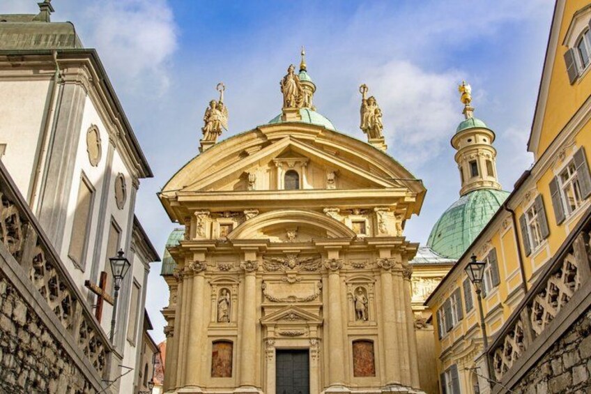 A historic building with ornate architecture, including a dome and statues. 5
