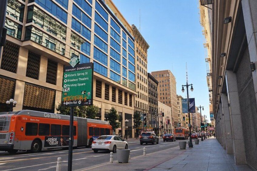A city street with a bus, cars, and a street sign. 3